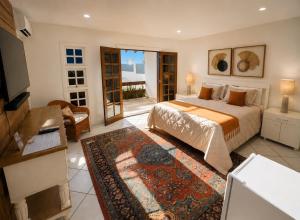 a bedroom with a bed and a living room at Luna Hotel Boutique - Frente à Praia in Guarujá