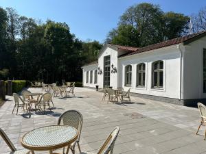 a patio with chairs and tables and a building at Orangeriet Björkelund in Skövde