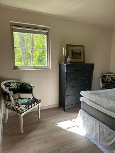 a bedroom with a bed and a chair and a window at Orangeriet Björkelund in Skövde