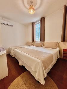 a bedroom with two beds and a window at Pousada Flores do Farol in Salvador +17 photos