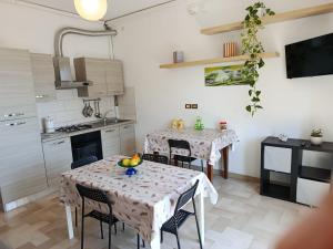 a kitchen with two tables and chairs in a room at Appartamenti Sole&Mare in Marotta