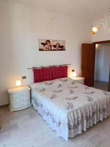 a bedroom with a large bed with red pillows at Appartamenti Sole&Mare in Marotta