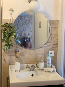 a bathroom sink with a mirror above it at La Petite Quinotte in Cadillac