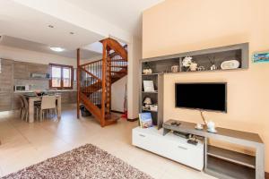 a living room with a television and a staircase at Getaway Npetto Gozitan Villa - Happy Rentals in Mġarr