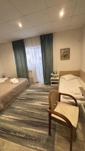 a hotel room with two beds and a chair at Vila Ispirescu INN in Cluj-Napoca