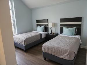 two beds in a room with two beds sidx sidx sidx sidx at Premier Downtown Koreatown Apartment in Los Angeles
