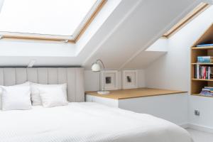 a bedroom with a white bed and a desk at Kopernik Loft Jelenia Góra in Jelenia Góra