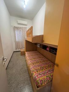 a small room with a bed and a staircase at Casa Fuxia in Marina di Cecina
