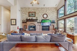 a living room with a large couch and a tv at Summit Sanctuary in Lake Arrowhead
