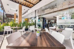 a restaurant with a wooden table and white chairs at Azor Hotel Cali Versalles in Cali +71 photos