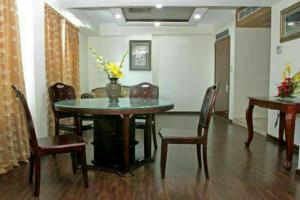 a dining room table with chairs and a vase with flowers on it at HOTEL FABULOUS KASHMIR, Dal lake in Srinagar