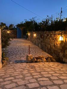a stone pathway with a stone wall at night at Dar Kmaar in Hammamet +5 photos