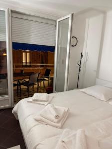 a white bed with two towels on top of it at Paula suite avec terrasse-Croisette, Plage Festival Palais in Cannes