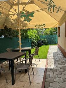 a patio with a table and chairs under an umbrella at Vila Ispirescu INN in Cluj-Napoca