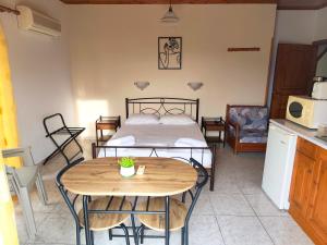 a room with a bed and a table and a kitchen at Hector's Studios in Alikanas