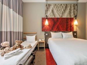 two beds in a room with two teddy bears at ibis Vilnius Centre in Vilnius +54 photos