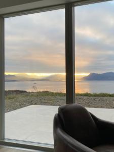 a living room with a couch and a large window at Skyelyne in Ardvasar +4 photos