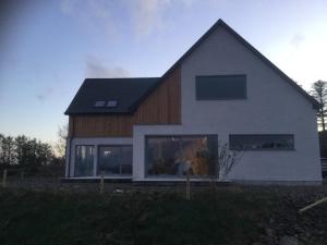 a house with a black roof and windows at Skyelyne in Ardvasar