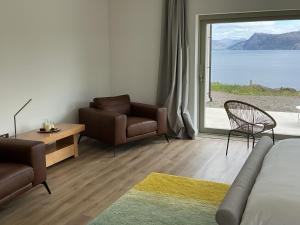 a room with a bed and a chair and a window at Skyelyne in Ardvasar