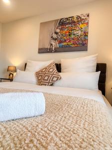 a bedroom with two beds and a painting on the wall at Moderne Ferienwohnung in Jettingen-Scheppach