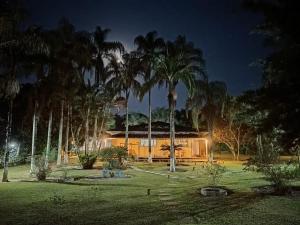 a house with palm trees around it at night at Villa Dona Jaca - Casa da Mata - Casa 02 in Socorro