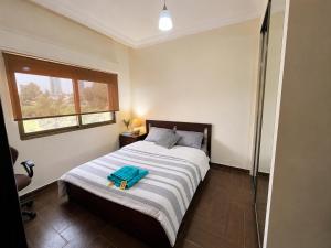 a bedroom with a bed with a blue bag on it at Cozy Central Secured Compound in Amman