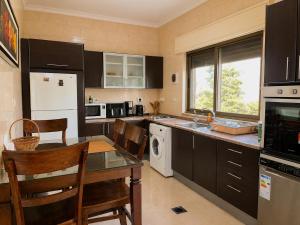 a kitchen with black cabinets and a table with chairs at Cozy Central Secured Compound in Amman +8 photos