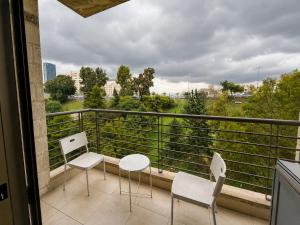 a balcony with two chairs and a table and a view at Cozy Central Secured Compound in Amman