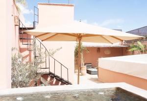 an umbrella sitting on the side of a building at Riad Lamzia in Marrakesh