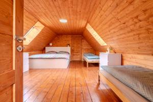 a room with two beds in a wooden cabin at Roubenka Kubovka in Černá v Pošumaví