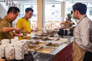 three men standing around a buffet preparing food at Casa Andora in Machu Picchu +19 photos