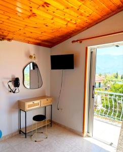 a room with a desk and a television and a window at Hector's Studios in Alikanas