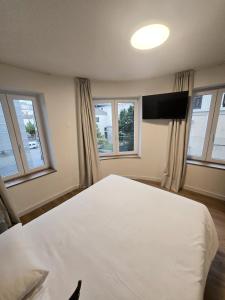 a bedroom with a large white bed and windows at B&H Boreal in Burgos