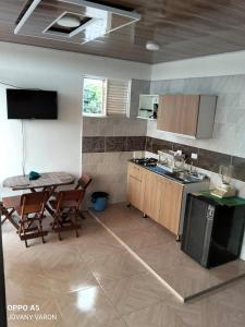 a kitchen with a table and chairs and a kitchen with a stove at Apartamento independiente, fresco y cómodo in Acacías