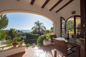 an outdoor patio with an archway and a table and chairs at Acuarela Vistas in Jávea