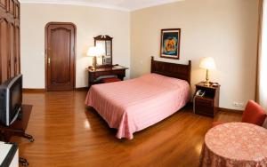a hotel room with a bed and a television at Hotel Aranjuez Cochabamba in Cochabamba