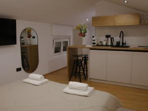 a kitchen with two white towels on top of a bed at Rentalica in Belgrade