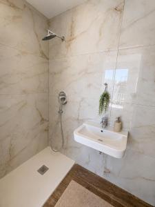a bathroom with a sink and a shower at Luna Suites in St. Julianʼs