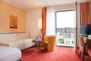 a hotel room with a couch and a window at Montana Hotel Mönchengladbach in Mönchengladbach