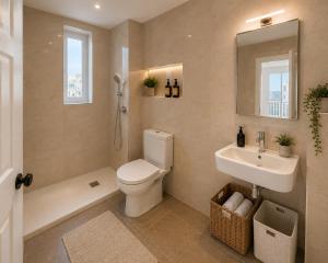 a bathroom with a toilet and a sink and a mirror at Luna Suites in St. Julianʼs
