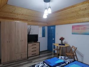a bedroom with a bed and a tv and a table at Casa de vacanta Amira in Sfântu Gheorghe