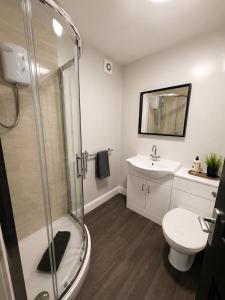 a bathroom with a shower and a toilet and a sink at Central Apartments Cannock in Cannock