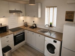 a kitchen with a washing machine and a sink at Central Apartments Cannock in Cannock