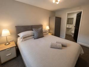 a bedroom with a large white bed and a bathroom at Central Apartments Cannock in Cannock