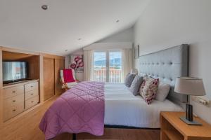 a bedroom with a large bed and a television at Atico Solpor Patos in Nigrán +11 photos