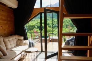 a living room with a couch and a large window at SeSam Villas in Theth