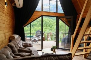 a living room with couches and a large window at SeSam Villas in Theth