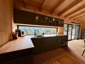 a kitchen with a sink and a large window at Steinberghaus am Rofan in Steinberg am Rofan