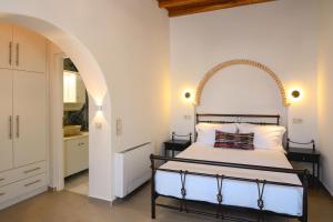 a bedroom with a bed with an arch above it at Villa Markiani in Aegiali +51 photos