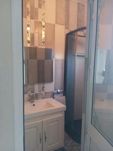 a bathroom with a sink and a mirror and a shower at Maison ras angela in Bizerte